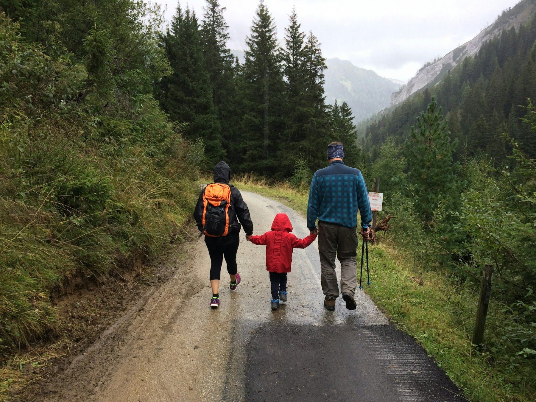 Une famille marche sur un chemin de montagne