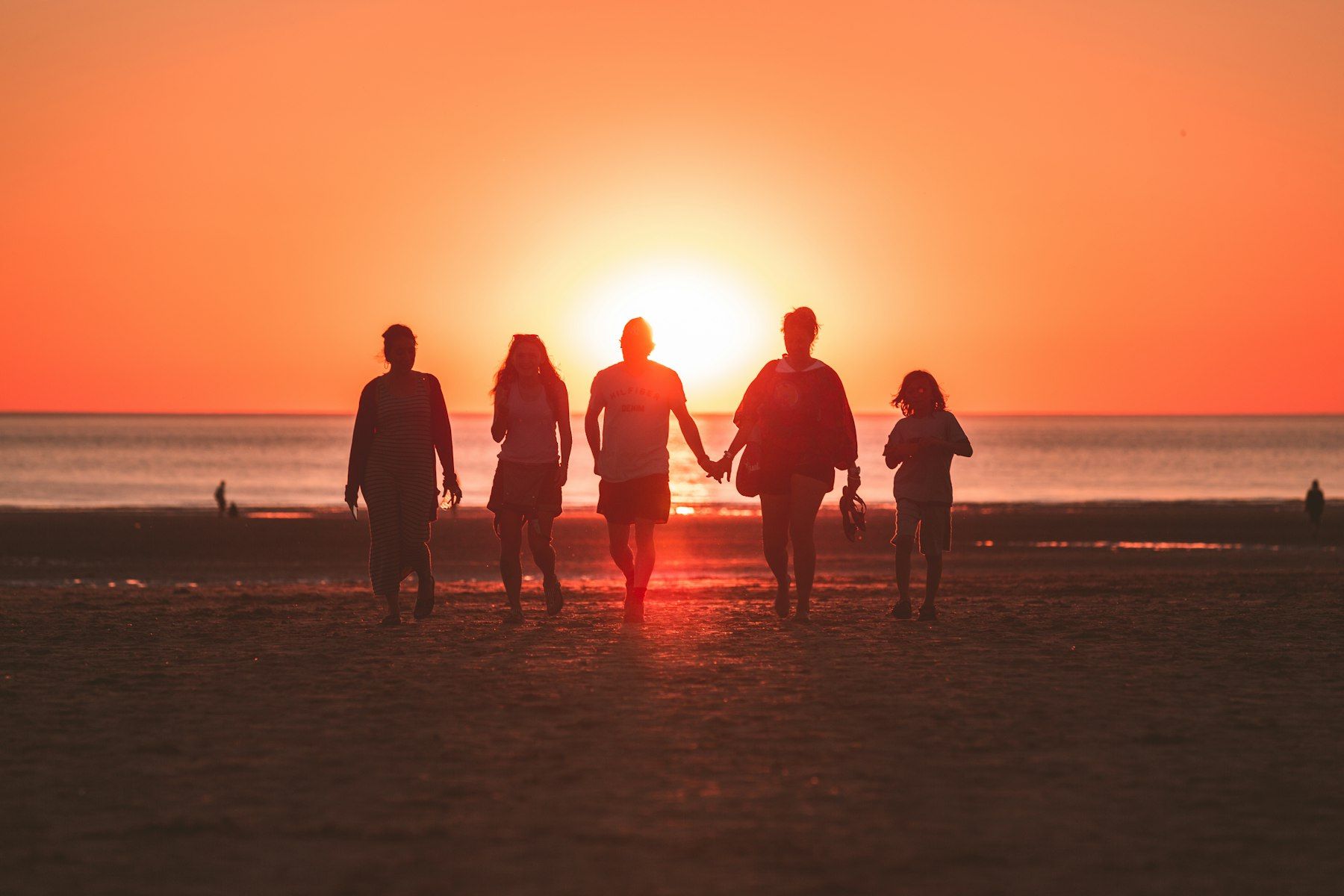 Une famille sur la plage au coucher du soleil